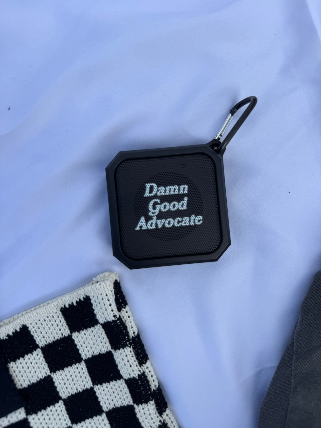 Black square device with 'Damn Good Advocate' text on a light blue background