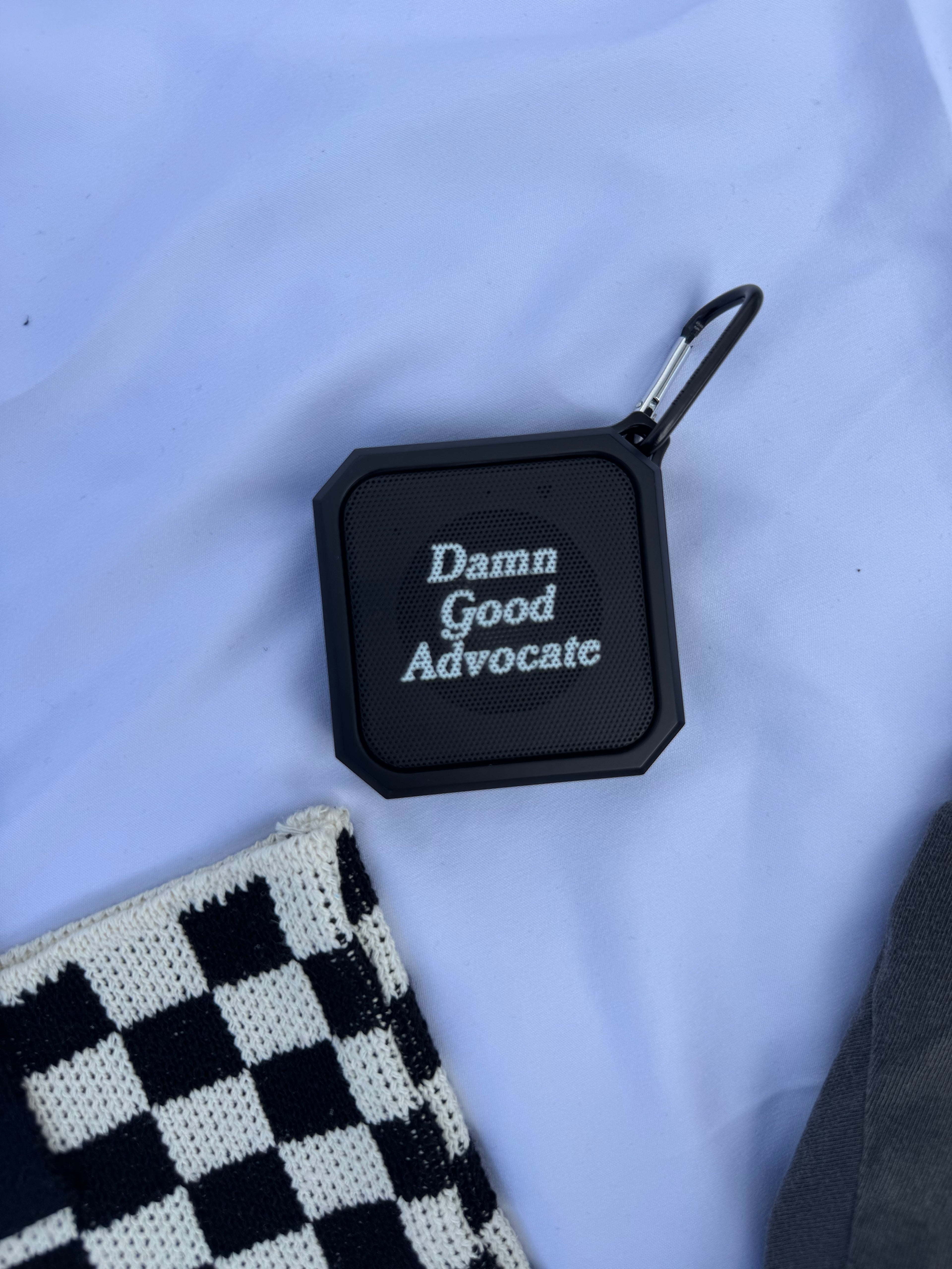 Black square device with 'Damn Good Advocate' text on a light blue background