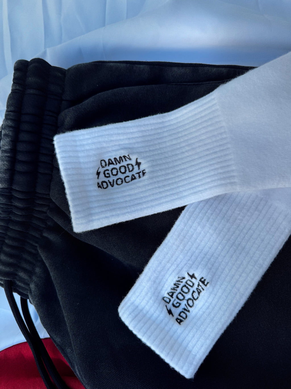 White socks with 'Damn Good Advocate' text on a black background